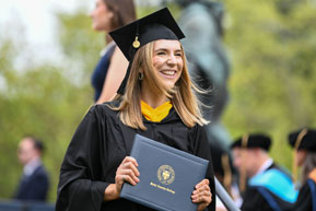 A graduating student holds her diploma. Links to Under Age 60