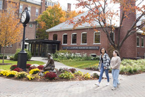 Students walk through campus together. Links to Closely Held Business Stock