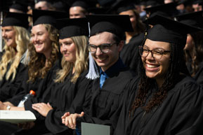 Students smile as they watch the graduation ceremony. Links to Ages 60–70 